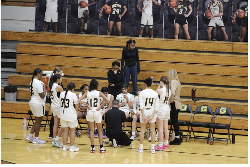 Coach Chris Tomsci discusses strategy with the Lady Panthers during a timeout. 